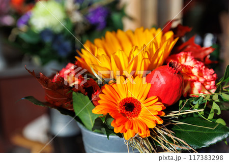 Vibrant Autumn Flower Bouquet in Rustic Metal Vase on wooden table at countryside village farm rustical house. Bright floral seasonal composition in bucket. Nature farmyard blossom arrangement 117383298