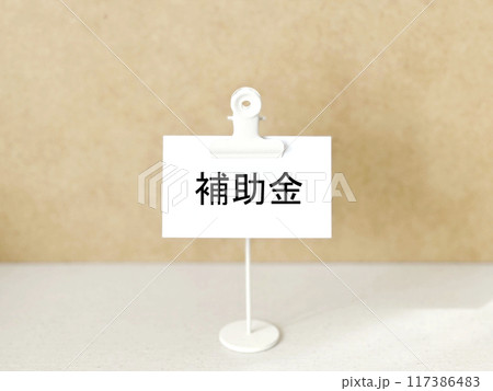 クリップスタンドにつけた白い紙に補助金の文字 117386483