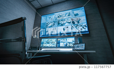 Surveillance footage displayed on computer monitors and big digital screen 117387757
