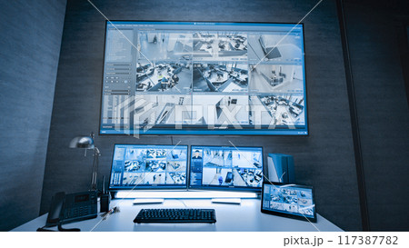 Surveillance footage displayed on computer monitors and big digital screen Surveillance footage displayed on computer monitors and big digital screen 117387782