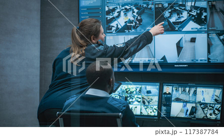 Multiethnic CCTV operators control security cameras on computer and tablet 117387784