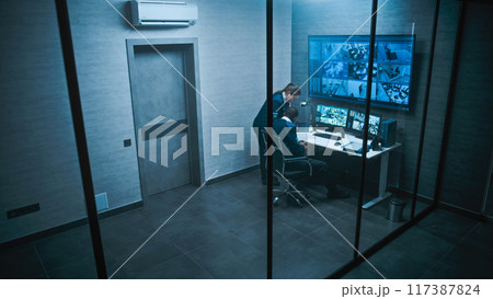 African American CCTV operator works on computer watching security cameras African American CCTV operator works on computer watching security cameras 117387824