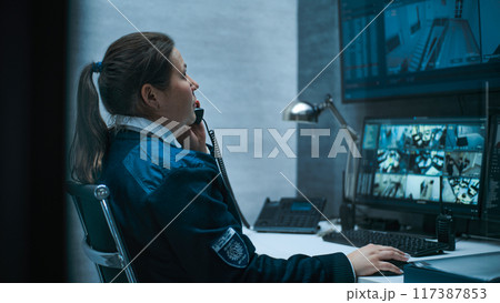 Female security worker or dispatch works on computer with CCTV cameras Female security worker or dispatch works on computer with CCTV cameras 117387853