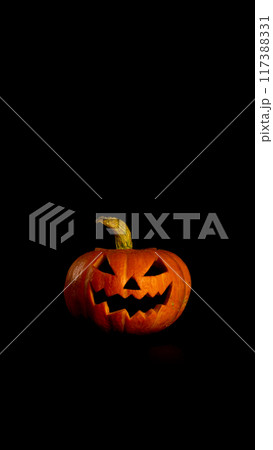 Happy Halloween, black background. Smiles orange pumpkin. Vertical banner postcard Happy Halloween, black background. Smiles orange pumpkin. Vertical banner postcard 117388331