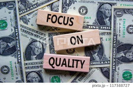 Focus on quality symbol. Concept words Focus on quality on blocks on beautiful background from dollar bills. Business, focus on quality concept. Copy space. 117388727