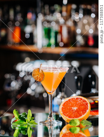 Vibrant grapefruit cocktail in a martini glass, perfect for summer parties or elegant gatherings Vibrant grapefruit cocktail in a martini glass, perfect for summer parties or elegant gatherings 117388851