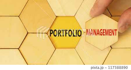 Portfolio management symbol. Concept words Portfolio management on beautiful wooden puzzles. Beautiful yellow background. Businessman hand. Business Portfolio management concept. Copy space. 117388890