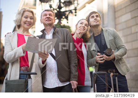 Couples of tourists look at a map and travel in a European city 117390419