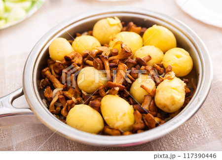 Delicious fried chanterelles with new potatoes in a frying pan Delicious fried chanterelles with new potatoes in a frying pan 117390446
