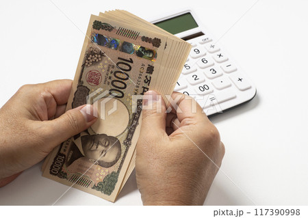 新紙幣の十万円を手に取る人のイメージ 117390998