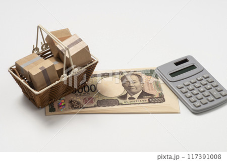 段ボール箱が入った買い物かごとお金と電卓 117391008