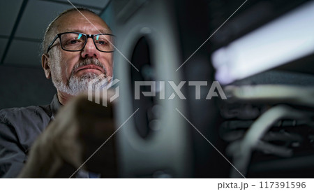 Close up of male system administrator setting up network equipment using tablet Close up of male system administrator setting up network equipment using tablet 117391596