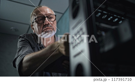 Close up of male system administrator setting up network equipment using tablet 117391710