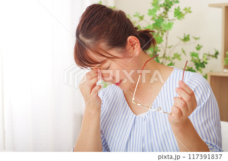 眼のトラブルで目頭を押さえるミドル女性 眼のトラブルで目頭を押さえるミドル女性 117391837