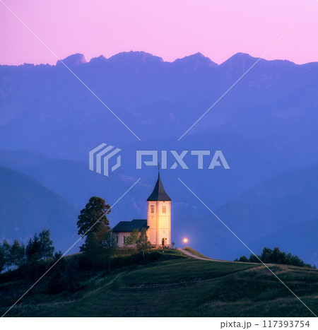 Church on a hill at dusk with mountain ranges in the background 117393754