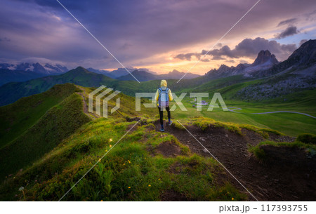 Woman with backpack and beautiful alpine mountain peaks at sunse 117393755