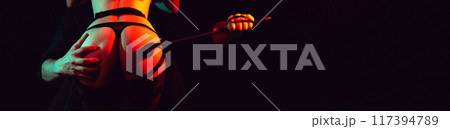 dominant man with whip flogger slaps the sexy ass of a submissive bottom woman slave girl. BDSM sex with submission and domination between couple. Wide banner with black background dominant man with whip flogger slaps the sexy ass of a submissive bottom woman slave girl. BDSM sex with submission and domination between couple. Wide banner with black background 117394789