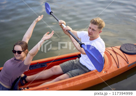 the couple in love kayaking on the river at sunset 117394999