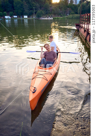 the couple in love kayaking on the river at sunset 117395003