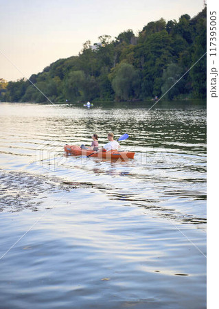 the couple in love kayaking on the river at sunset 117395005