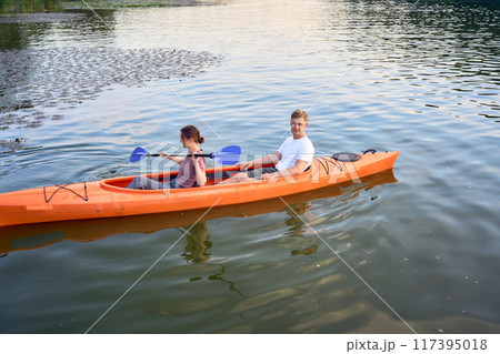 the couple in love kayaking on the river at sunset 117395018