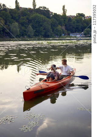 the couple in love kayaking on the river at sunset 117395032