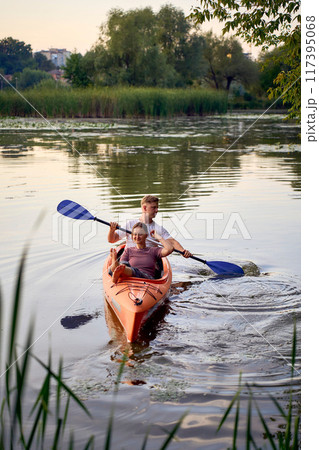 the couple in love kayaking on the river at sunset 117395068