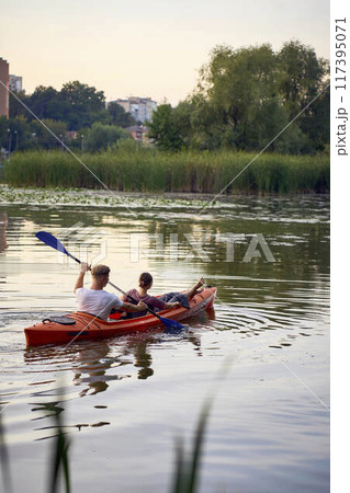 the couple in love kayaking on the river at sunset 117395071