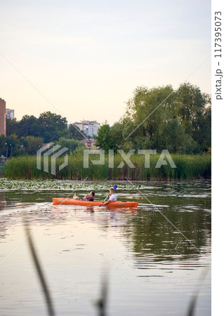 the couple in love kayaking on the river at sunset 117395073