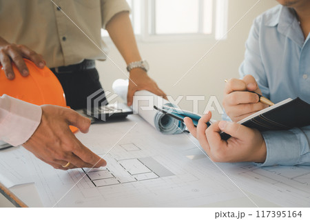 Confident team of architect working together in a office.Then discussing about new startup project on desk. Architect discuss with engineer about project in office, architectural concept. 117395164