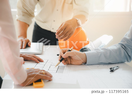 Confident team of architect working together in a office.Then discussing about new startup project on desk. Architect discuss with engineer about project in office, architectural concept. 117395165