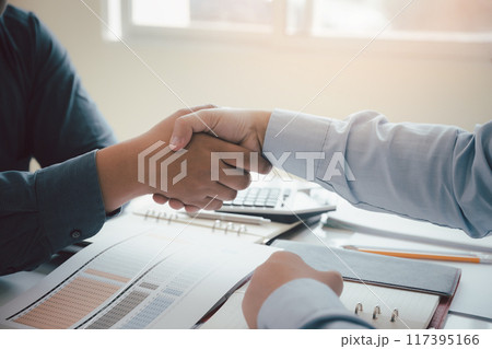 Business people shaking hands, finishing up a meeting. Two confident business man shaking hands during a meeting in the office, success, dealing, greeting and partner concept. 117395166