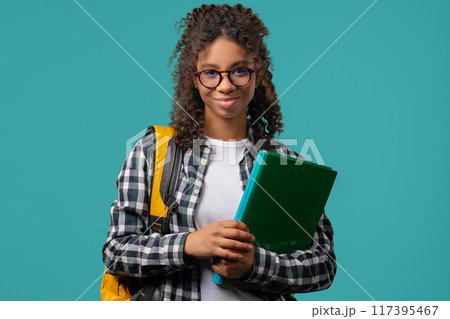 Portrait of high school smiling african american student girl with papers folder. Academic teen, education, university concept. Portrait of high school smiling african american student girl with papers folder. Academic teen, education, university concept. 117395467