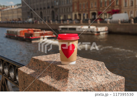 Brown cup of natural coffee with red heart on bridge near embankment of Fontanka river in St. Petersburg Brown cup of natural coffee with red heart on bridge near embankment of Fontanka river in St. Petersburg 117395530