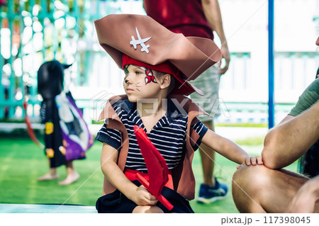 Boy Cat Pirate costume. Halloween party in kindergarten. Aqua makeup painted kids face. Bright festive Boy Cat Pirate costume. Halloween party in kindergarten. Aqua makeup painted kids face. Bright festive 117398045