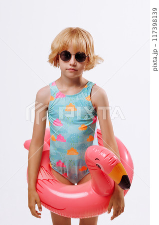 Child with inflatable duck ring on blue background with copy space. Child with inflatable duck ring on blue background with copy space. 117398139