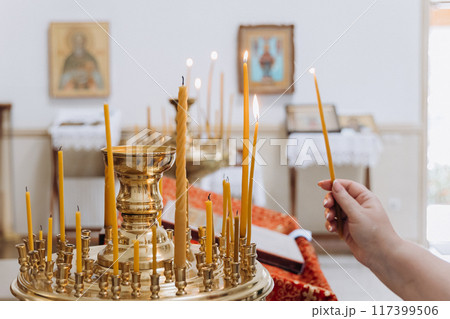 Lighting candles in a church ceremony, symbolizing faith, prayer, and spiritual connection 117399506