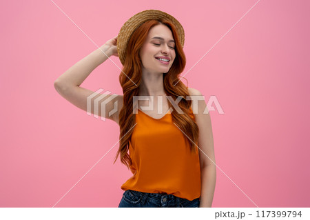 Pretty flirty young woman in straw hat looking contented 117399794