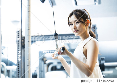 スポーツジムでトレーニングする若い女性　カメラ目線 117402258