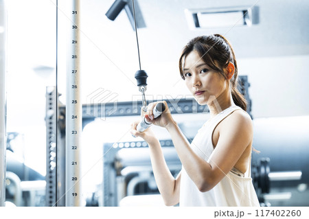 スポーツジムでトレーニングする若い女性 カメラ目線 スポーツジムでトレーニングする若い女性 カメラ目線 117402260