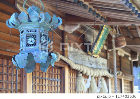 神社の拝殿の屋根に吊るされた灯篭 117402636