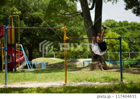 真夏の公園で鉄棒を遊んでいる小学生の女の子の様子 真夏の公園で鉄棒を遊んでいる小学生の女の子の様子 117404635