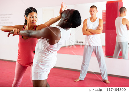 Man and woman exercising during self-defence training 117404800