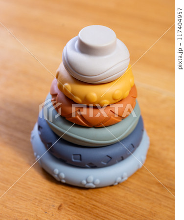 Childrens pyramid made of round ring elements stands on wooden table Childrens pyramid made of round ring elements stands on wooden table 117404957