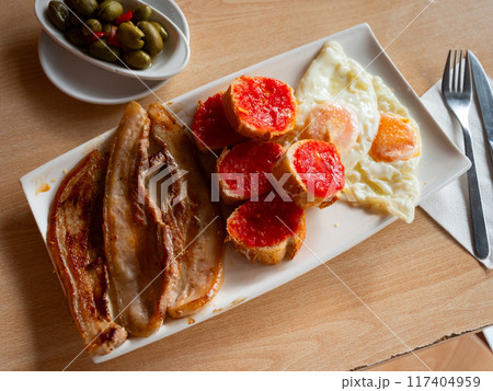 Tasty nutritious breakfast of bacon and scrambled eggs closeup 117404959