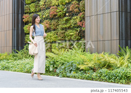 壁面緑化されたビルの前を歩くビジネスウーマン 117405543
