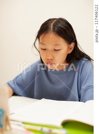 夏休みの小学生の女の子が楽しく宿題をする様子 117406122