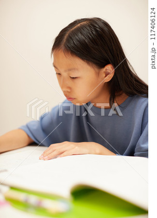 夏休みの小学生の女の子が楽しく宿題をする様子 117406124