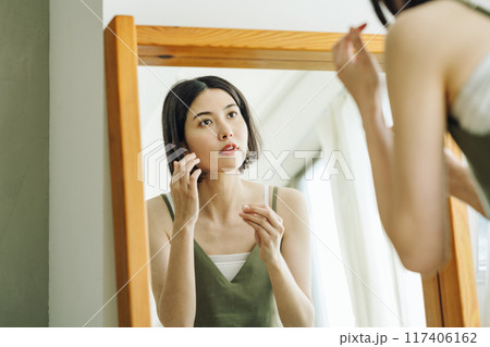鏡を見て身支度する女性 鏡を見て身支度する女性 117406162