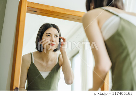鏡を見て身支度する女性 117406163